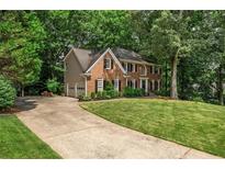 Traditional brick home featuring a two-car garage, manicured lawn, and mature landscaping in a desirable neighborhood at 4971 Fairhaven Ne Way, Roswell, GA 30075