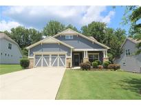 Charming single-story home featuring a welcoming front porch, well-manicured lawn, and a two-car garage at 5714 Pickens Garden Ln, Powder Springs, GA 30127