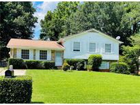 Charming home with white siding, well-manicured lawn, and mature trees providing ample shade at 8436 Magnolia Dr, Jonesboro, GA 30238