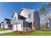 Two-story home featuring a two-car garage, gray siding, and a well-maintained lawn at 145 Weldon Rd, Mcdonough, GA 30253