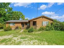 Cozy one-story home featuring a covered porch, wood siding, and a well-maintained lawn at 1198 Old Mill Rd, Dallas, GA 30157