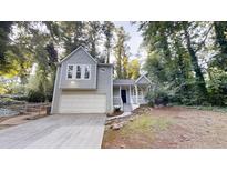 Charming two-story home with a well-maintained front yard and attached garage nestled among mature trees at 733 Emerald Forest Cir, Lawrenceville, GA 30044
