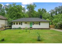 Charming ranch-style home features a well-maintained lawn, a modern green door, and lush surrounding greenery at 2049 Rector Dr, Atlanta, GA 30311
