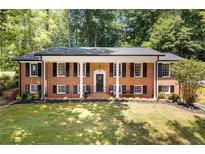 Inviting brick home featuring a white-columned front porch and mature landscaping for enhanced curb appeal at 2658 Briarlake Ne Rd, Atlanta, GA 30345