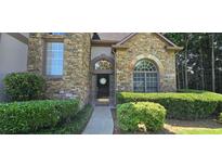 Charming stone-clad home featuring arched windows and a well-maintained front garden at 3310 Mcclure Woods Ct, Duluth, GA 30096