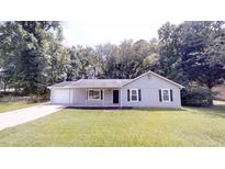 Charming single-story home featuring a well-manicured lawn and a welcoming front porch at 3136 Palomino Dr, Powder Springs, GA 30127