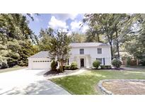 Charming two-story home featuring a well-manicured lawn, mature trees, and a classic exterior design at 3695 Fox Hills Se Dr, Marietta, GA 30067