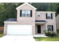 Charming two-story home featuring a brick facade, attached two-car garage, black shutters, and landscaped yard at 5626 Laurel Ridge Dr, Atlanta, GA 30344