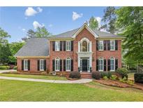 Beautiful two story brick home with a landscaped yard, black shutters and trimmed bushes in front at 730 Mount Oglethorpe Trl, Alpharetta, GA 30022