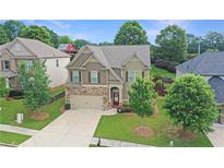Charming two-story home with stone accents, a well-manicured lawn, and mature trees in a desirable neighborhood at 2325 Lake Cove Ct, Buford, GA 30519