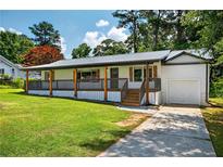 Charming single-story home featuring a welcoming front porch and well-maintained lawn at 5619 Beaver Sw Dr, Mableton, GA 30126