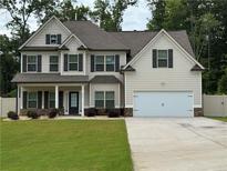Charming two-story home with a well-manicured lawn and a two-car garage at 5890 Crowley Dr, Douglasville, GA 30135