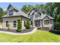 Beautiful home with well-manicured lawn and mature landscaping at 619 Lovinggood Trl, Woodstock, GA 30189