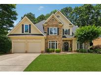 Beautiful two-story home featuring a stone facade, well-manicured lawn, and a two-car garage at 1125 Fairview Club Cir, Dacula, GA 30019