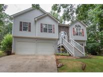 Charming two-story home with a two-car garage, manicured lawn and inviting stairway to the front entrance at 241 Lost Lake Way, Villa Rica, GA 30180