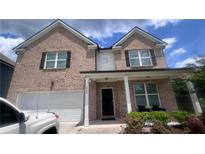Charming two-story brick home featuring a welcoming front porch and well-maintained landscaping at 3750 Richmond Bnd, Lithonia, GA 30038