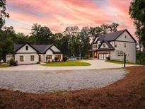 Stunning modern farmhouse-style homes with a beautiful lawn, pool, and driveway; perfect for luxurious country living at 3640 Pollys Blf, Cumming, GA 30028
