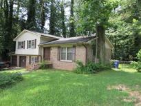 Two-story brick and siding home with front lawn and mature trees at 5114 Fawn Se Trl, Mableton, GA 30126