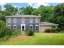 Charming two-story home featuring blue siding, white trim, a manicured lawn, and mature landscaping at 2340 Castleridge Ct, Tucker, GA 30084