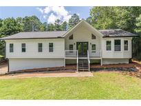 Charming renovated home with a gabled roof, front porch and manicured front lawn at 243 Hickory Way, Canton, GA 30115