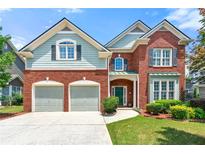 Charming brick home featuring a two-car garage, manicured lawn, and inviting curb appeal at 1999 Barrett Knoll Nw Cir, Kennesaw, GA 30152