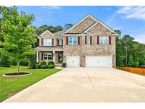 Charming two-story brick home with a well-manicured lawn and a spacious driveway leading to a two-car garage at 3865 Rifflepool Ct, Douglasville, GA 30135