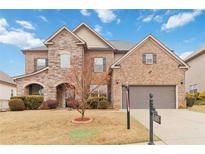 Charming two-story home with stone and brick facade, manicured lawn, and attached two-car garage at 4808 Albany Way, Atlanta, GA 30331