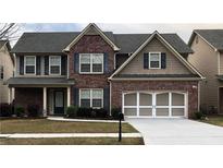 Charming two-story brick home with blue shutters, well-manicured lawn and two car garage at 3299 Arbor Oaks Dr, Snellville, GA 30039