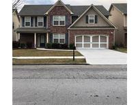Charming two-story brick home with a well-manicured lawn and an attached two-car garage at 3299 Arbor Oaks Dr, Snellville, GA 30039