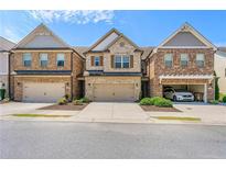 Beautiful brick townhome with two car garage and manicured landscaping at 8295 Village Pl, Suwanee, GA 30024