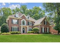 Elegant brick home with a lush green lawn and manicured landscaping at 1140 River Laurel Dr, Suwanee, GA 30024