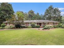 Charming single-story brick home featuring a lush green lawn and meticulously landscaped front yard at 2221 Fairoaks Rd, Decatur, GA 30033