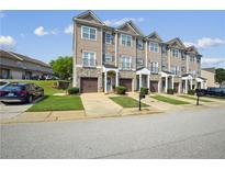 Charming townhome showcases a stone and siding facade, inviting front entrance and attached garage at 7710 Bucknell Terrace, Fairburn, GA 30213