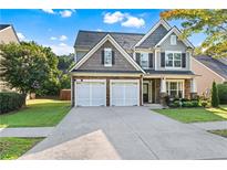 Charming two-story home with a two-car garage, manicured lawn, and stone and siding facade at 2481 Southhaven Ln, Buford, GA 30519