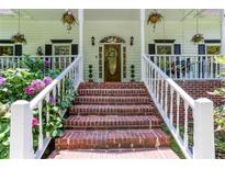 Inviting brick steps lead to the front door of this home with lush landscaping at 5491 Hiram Rd, Powder Springs, GA 30127