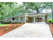 Charming brick home featuring a covered carport and a welcoming front porch at 2416 Timber Ridge Ct, Decatur, GA 30032
