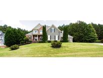 Charming home with a lush green lawn and mature trees offering curb appeal at 240 Chandler Walk, Loganville, GA 30052