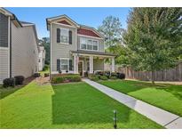 Charming two-story home with manicured lawn, walkway, and inviting covered front porch at 4571 Academy St, Acworth, GA 30101