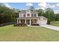 Inviting two-story home with a columned front porch and well-manicured lawn surrounded by mature trees at 404 Arden, Ellenwood, GA 30294