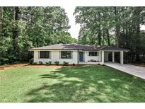 Charming brick home with manicured lawn, blue front door, and a convenient porte cochere at 437 Valley Brook Ne Dr, Atlanta, GA 30342