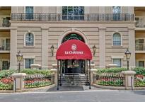 Elegant building entrance features a red awning and well-manicured landscaping for a welcoming feel at 2865 Lenox Ne Rd # 103, Atlanta, GA 30324