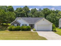 Charming one story home on a landscaped lot with a two-car garage and a welcoming front lawn at 706 Hillmont Dr, Loganville, GA 30052