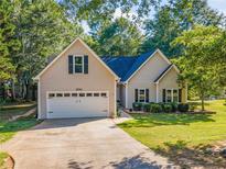 Charming home featuring a two-car garage and a well-maintained lawn, nestled among mature trees at 3540 Pilgrim Mill Rd, Cumming, GA 30041