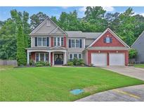 Charming two-story home boasts a brick and siding facade, lush lawn, and attached two-car garage at 1019 Avonley Creek Trce, Sugar Hill, GA 30518