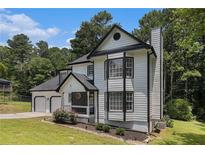 Charming two-story home with black and white trim, and a lush green lawn at 6492 Swift Creek Road, Lithonia, GA 30058