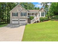 Charming split-level home with a well-manicured lawn, two-car garage, and inviting front porch at 15 Miners Pt Se, Acworth, GA 30102