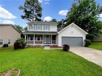 Charming two-story home featuring a covered front porch and well-manicured lawn at 268 Heathrow Dr, Riverdale, GA 30274