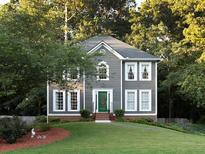 Charming two-story home featuring gray siding, white trim, manicured lawn, and lush landscaping at 4601 Gann Sw Xing, Smyrna, GA 30082