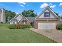 Charming single-story home with brick accents, a well-manicured lawn, and an attached two-car garage at 70 Prince Edward Way, Covington, GA 30016