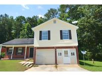 Charming two-story home featuring a garage, well-maintained lawn and an inviting front entrance at 2172 Cold Springs Cir, Lithonia, GA 30058